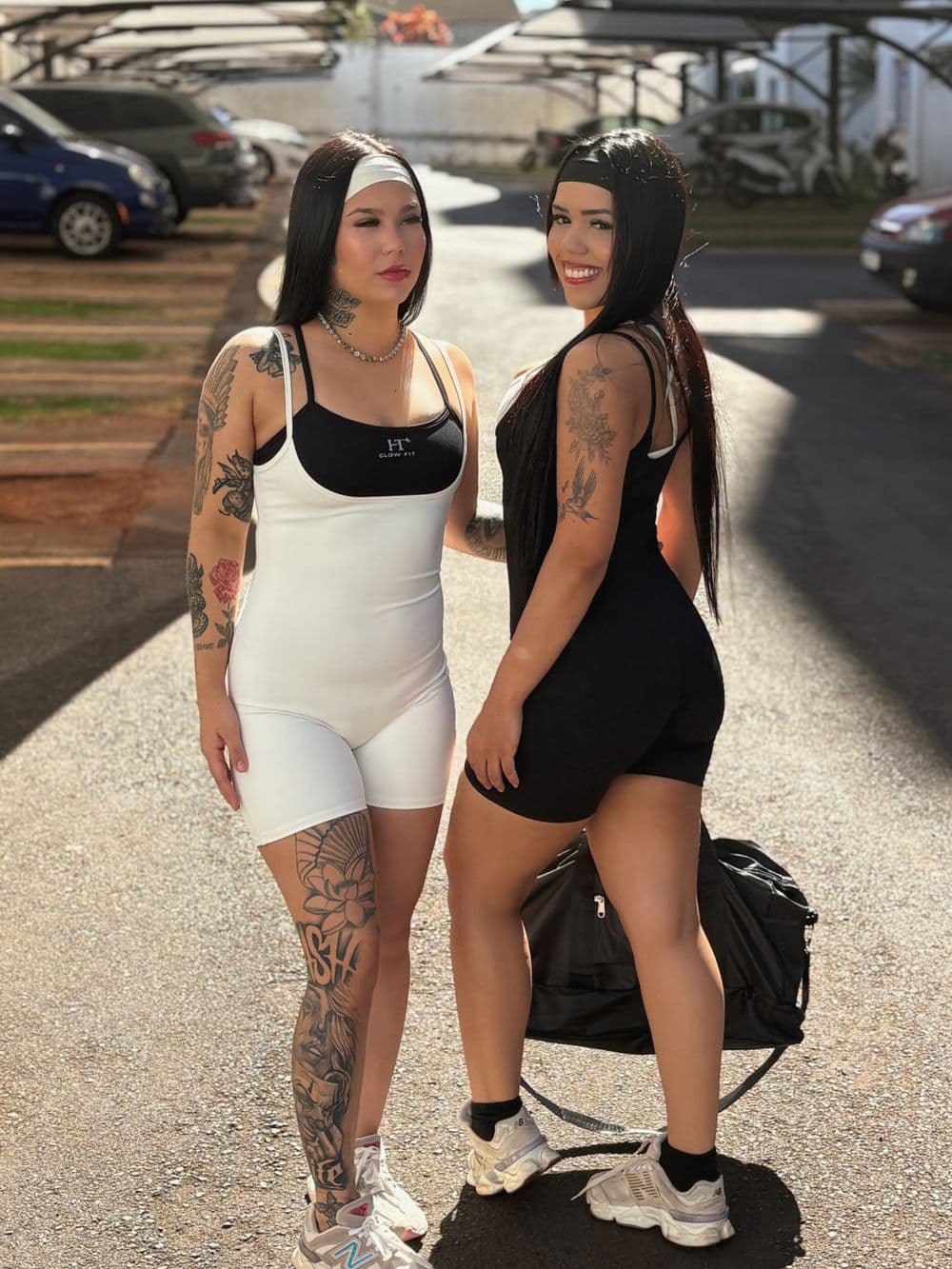 Duas amigas vestindo peças HT Glow Fit em branco e preto